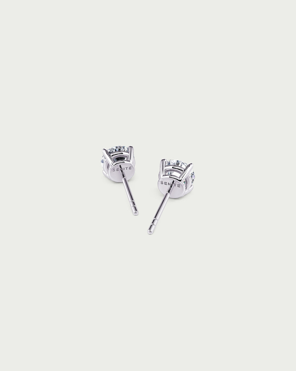 solo product shot of 18k white gold lab grown diamond stud earrings on off-white background