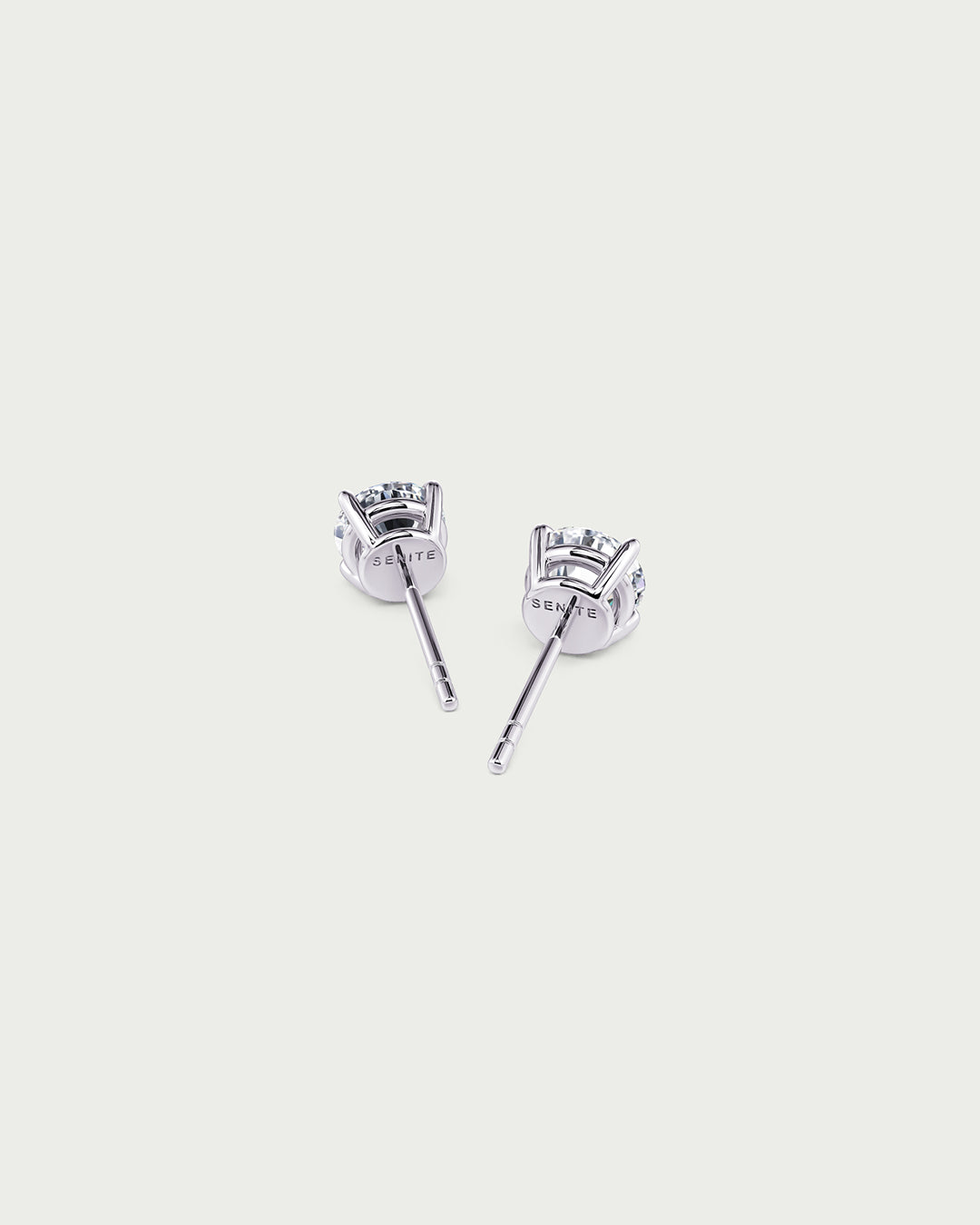 solo product shot of 18k white gold lab grown diamond stud earrings on off-white background