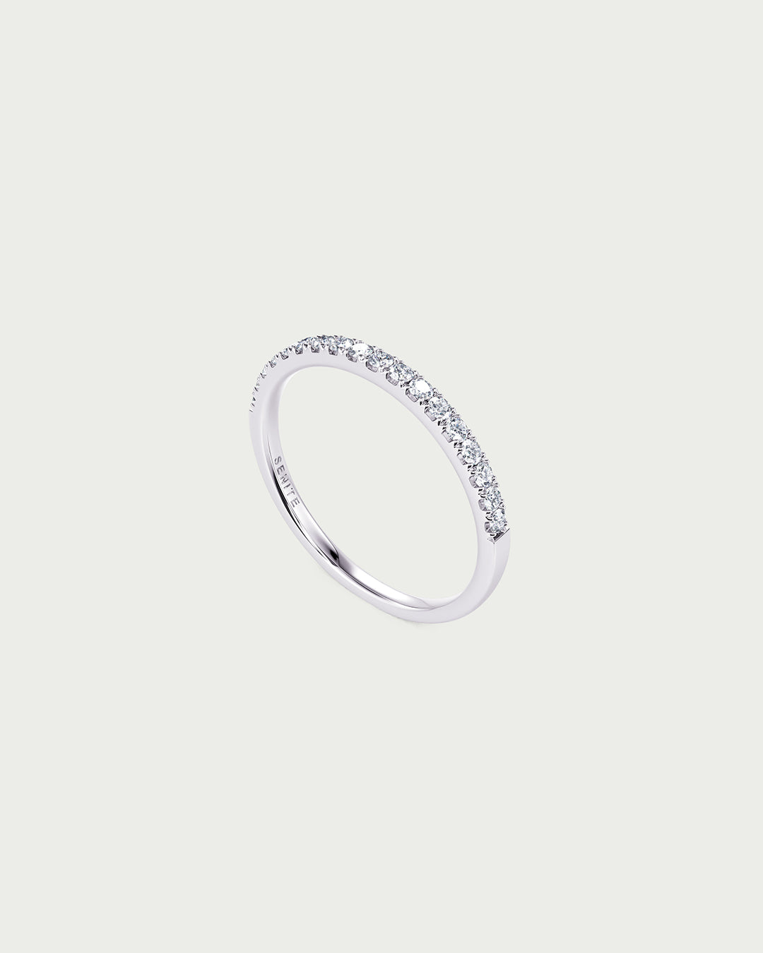 solo product shot of 18k white gold lab grown diamond half eternity band ring on off-white background