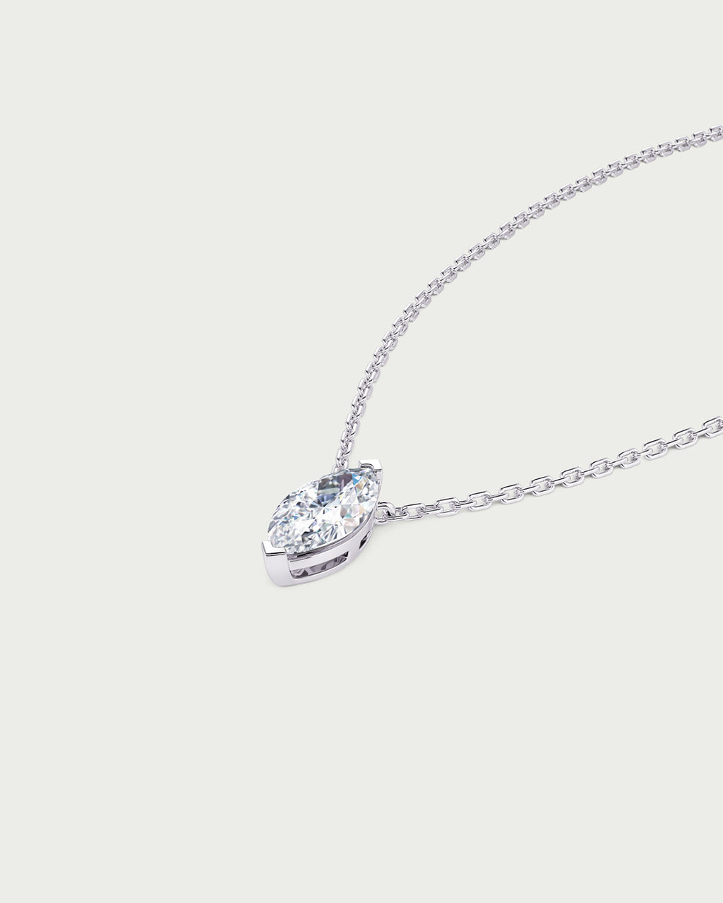 solo product shot of 18k white gold lab grown diamond marquise pendant necklace on off-white background