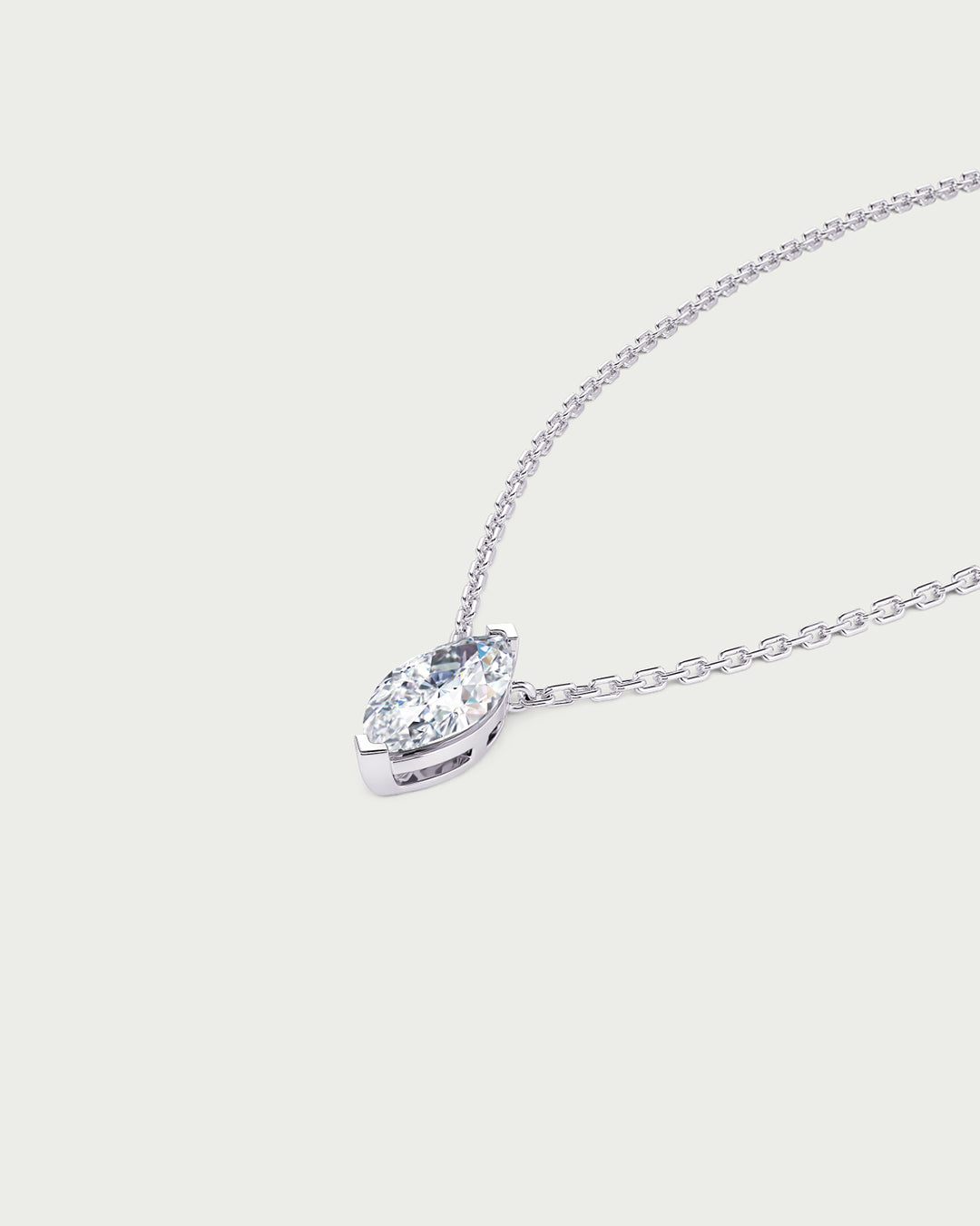 solo product shot of 18k white gold lab grown diamond marquise pendant necklace on off-white background
