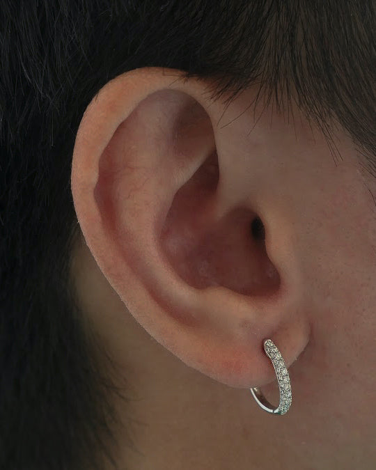 closeup of man's ear, ear has one 18k white gold diamond hoop on it